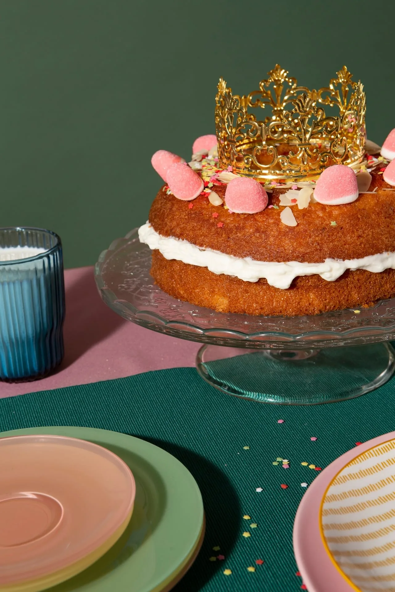 Hands carefully piping frosting onto a celebration cake in soft morning light